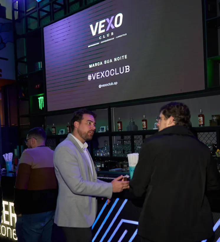 Convidados conversando no bar durante evento