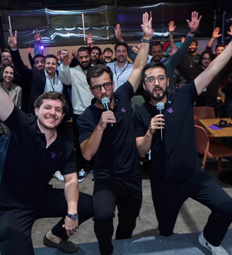 Time comemorando com os braços para cima no palco
